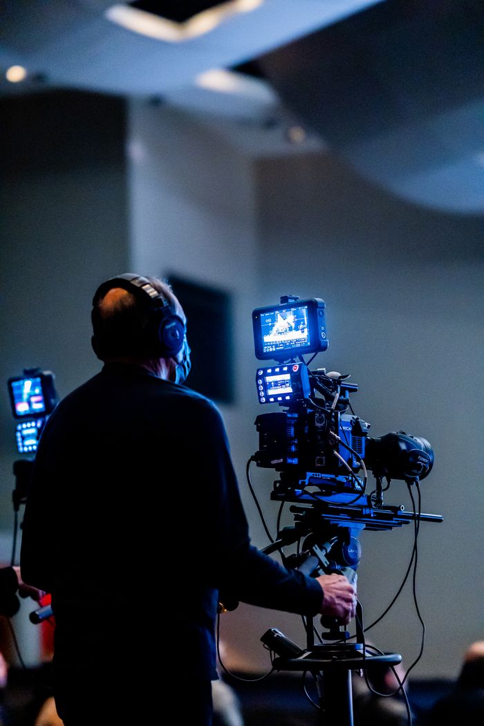 our-story Expert cameraman recording with high-tech video camera in a studio setting.