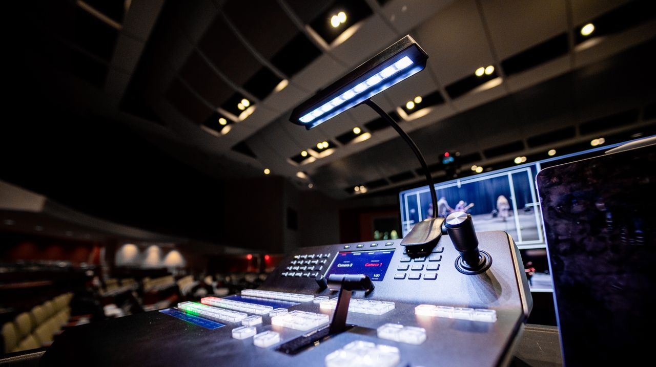 about-img Contemporary music console with buttons and glowing lamp under ceiling with lights in dark studio
